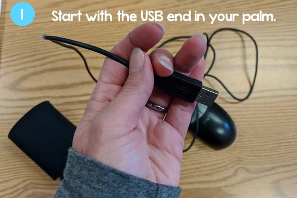 hand holding the USB end of a computer mouse