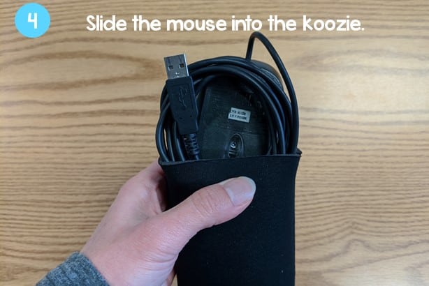 hand putting the computer mouse neatly into the can koozie
