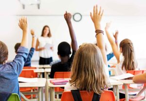 Teach students important procedures like raising hands to speak on the first day of school.